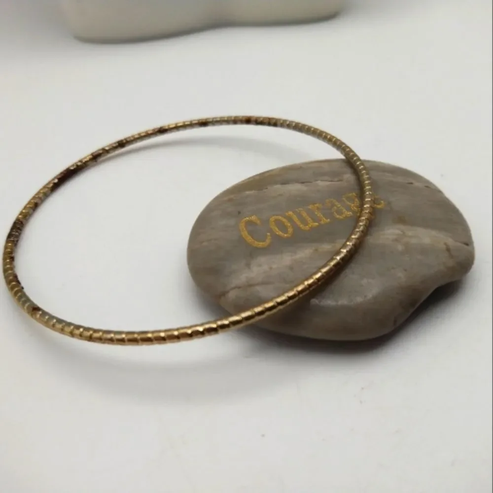 Chicken tracks gold toned round bracelet bangle